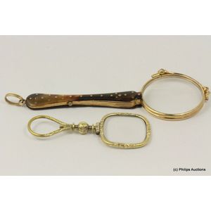 An antique magnifying glass and pair of lorgnettes, both rolled…