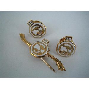 Three 9ct gold Qantas Long-Services badges, each with a small…
