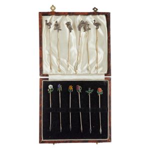 Twelve silver cocktail spikes, six decorated with Australian…