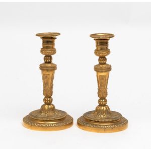 A pair of late baroque silvered brass altar candlesticks, first