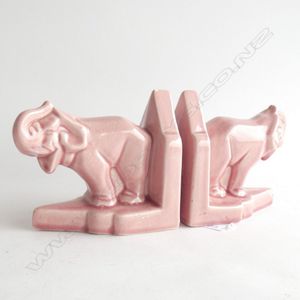 A pair of Art Deco cubist pink elephant Bookends, trunks raised,…