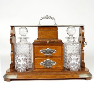 An impressive Edwardian oak tantalus, with two decanters and…