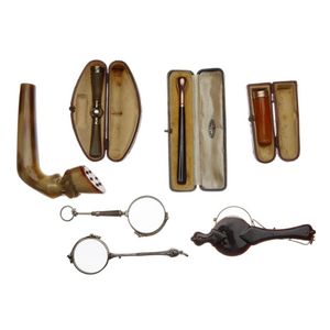 A carved horn walking stick handle, two cigarette holders and…