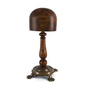 A shop display hat block, turned wood on brass base, late 19th…