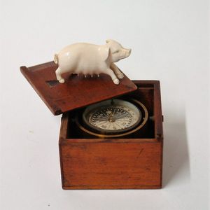 A c.1900 small gimballed compass and finely carved ivory pig,…