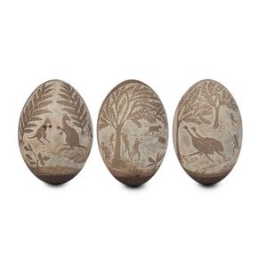 Three folk art carved emu eggs with Aboriginal hunting scenes,…