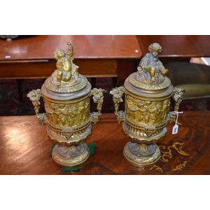 A pair of 19th century bronze mantle urns with putti and baccus…