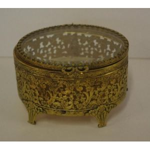 Gilt oval shape jewellery box with pierced body and glass top,…