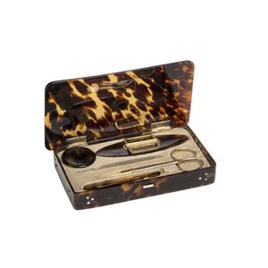 A tortoise shell etui with gold initial badge on the lid and…