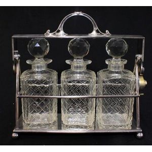 A James Dixon & Sons silver-plate three-bottle tantalus, chips…