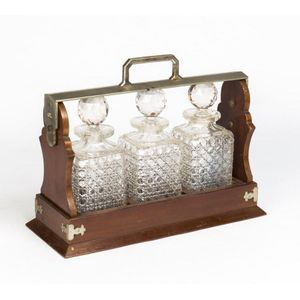A Tantalus with 3 hobnail cut crystal decanters, late 19th…