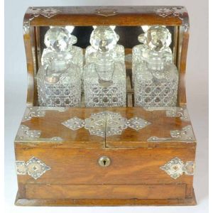 A Victorian oak & silvered metal bound, three, bottle tantalus,…