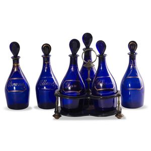 A set of 6 Bristol blue glass decanters and one ebony stand,…