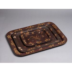 A set of three English lacquered and gilded papier- mache trays,…