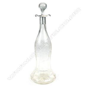 A tall bell shaped crystal decanter with silver collar and…