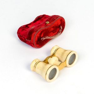 An Edwardian pair of ivory mounted opera glasses in a red felt…