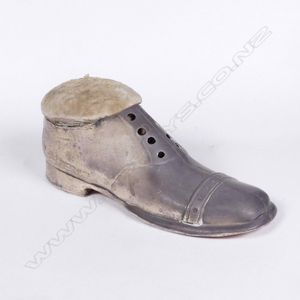 A late Edwardian silver pin cushion, in the form of a shoe,…