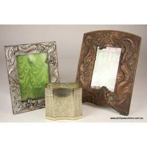 A Chinese metal tobacco box and two picture frames, the…