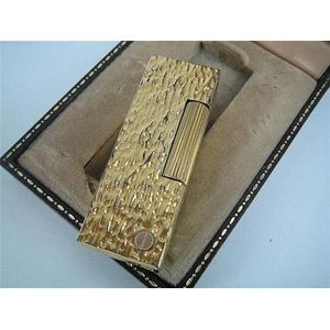 A Dunhill gold-plated cigarette lighter with bark finish.…