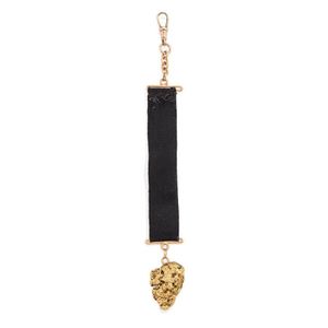 A ribbon fob with gold nugget. Yellow gold. Total weight 18…