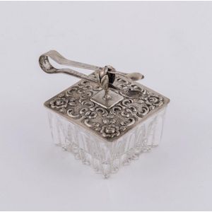 A German silver topped crystal pill box with accompanying tongs,…
