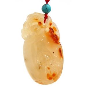 A carved white agate toggle with russet tones, the natural…