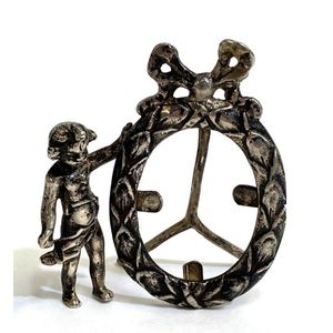 A silver metal oval frame, bow & putti detail with unverified…