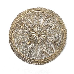 A silver metal filigree circular brooch with unverified Russian…
