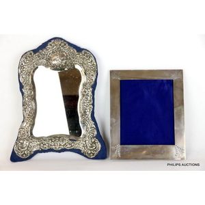 An Edwardian silver framed mirror, and a later photo frame, the…