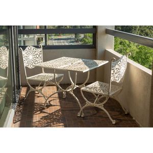 An ornate painted metal outdoor table and with matching chairs,…