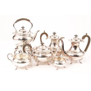 A silver plate six piece tea service includes spirit tea kettle,…