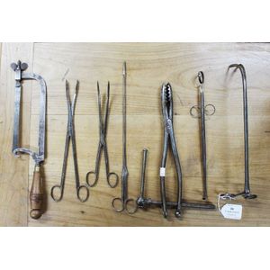 Antique medical instruments including a bone saw, forceps,…