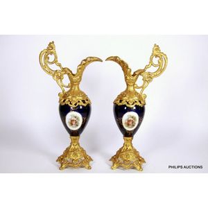 A pair of French porcelain and gilded spelter ewers, late 19th…