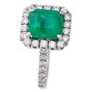 An emerald and diamond ring, featuring a square emerald cut…