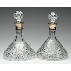 A pair of cut glass ship decanters with silver collars, height…