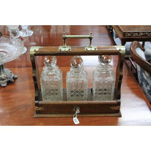 An English oak cased three bottle tantalus with hobnail cut…
