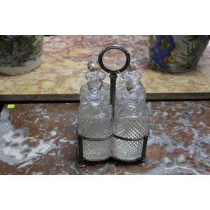 An English four bottle tantalus stand. Having four hobnail cup…