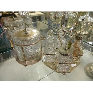 A crystal ice bucket in silver plated stand and a four bottle…