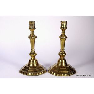 Lot - CONTINENTAL BRASS PRICKET STICK AND A CANDLESTICK, ON CAPSTAN TYPE  BASES