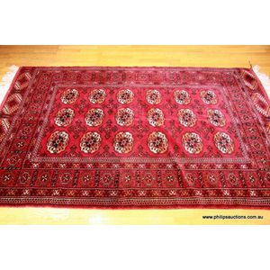 A fine Turkoman wool carpet, 20th century Iran, in ruby red…