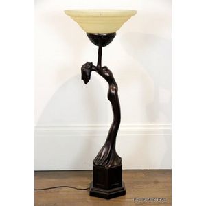 A large figural lamp, the bronze-look resin lamp base in the…