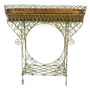 An old French iron planter, ornately decorated and with…