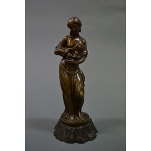 A bronze figure of a lady holding two doves, mounted on a cast…
