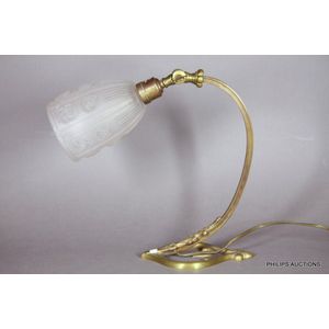An Art Deco bronze desk lamp, circa 1920s-30s, with an arching…