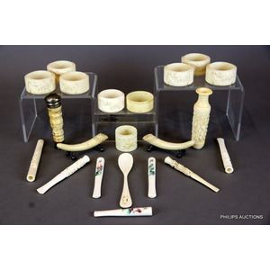 A mixed collection of vintage ivory cigarette holders, napkin…