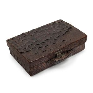 An antique crocodile skin travel case with fitted interior,…