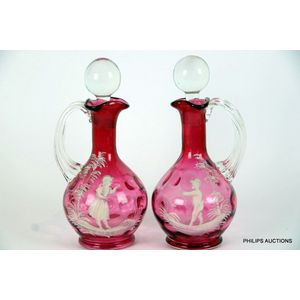 A pair of Mary Gregory cranberry glass decanters, late 19th…