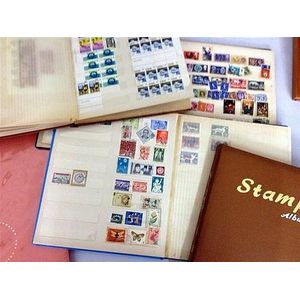 Four large stamp albums including stamps from around the world