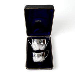 A boxed set of late Victorian silver cream and sugar, half…