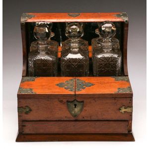 An oak Compartmental tantalus with three decanters and hidden…